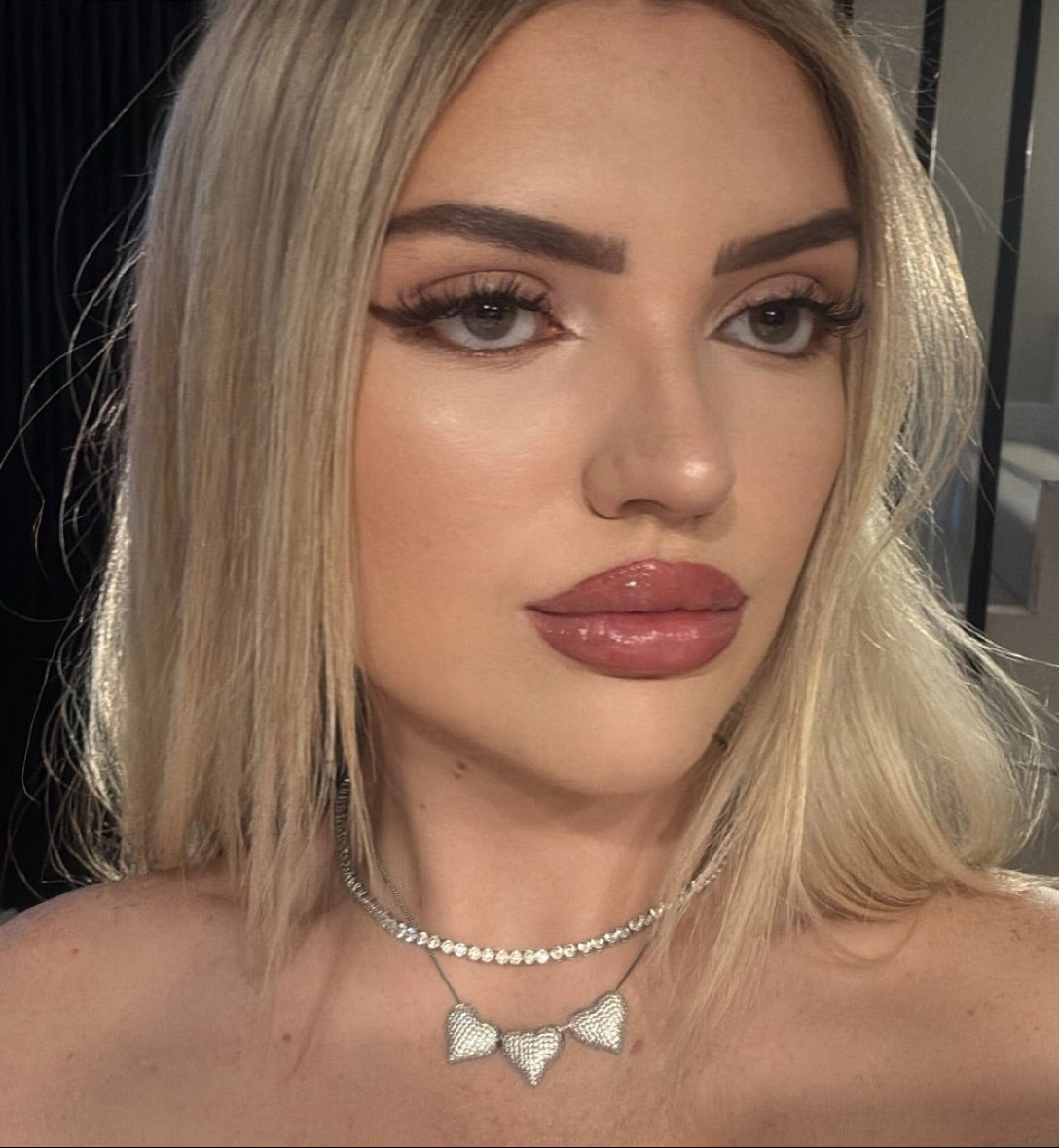 Model wearing the Triple The Love Necklace with three pavé heart pendants